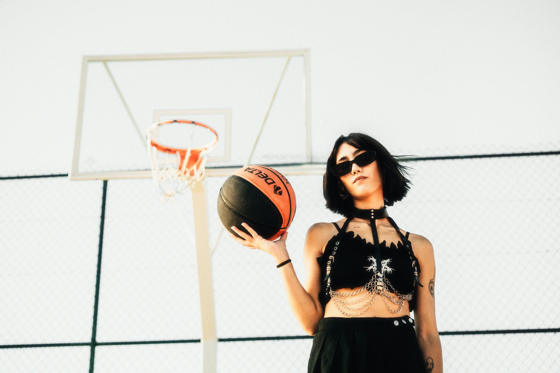 woman in sunglasses standing with basketball ball